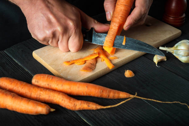 istock A professional chef peels carrots for vegetable soup in a restaurant kitchen. Close-up - hands of the cook during work. Carrot diet 1471860319