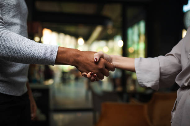 istock Two multiracial business colleagues working after work or during coffee break in a restaurant. Man and woman shaking hands after successful meeting.. 1471862027