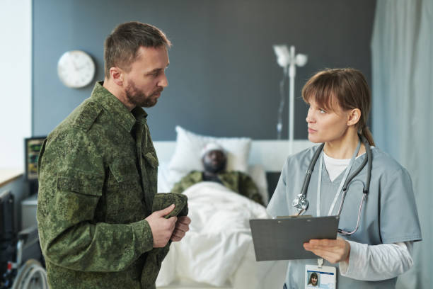istock Young female physician making notes in document and talking to soldier 1471865874