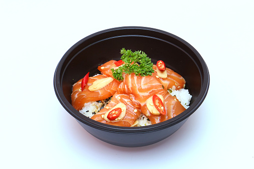 Salmon marinated shoyu or salmon pickled soy sauce and rice in a black tray. Japanese Style or Korean style. on a white background.