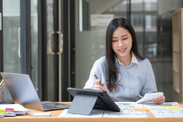 istock An Asian businesswoman using a digital tablet while sitting at a work desk in an office. 1471869119