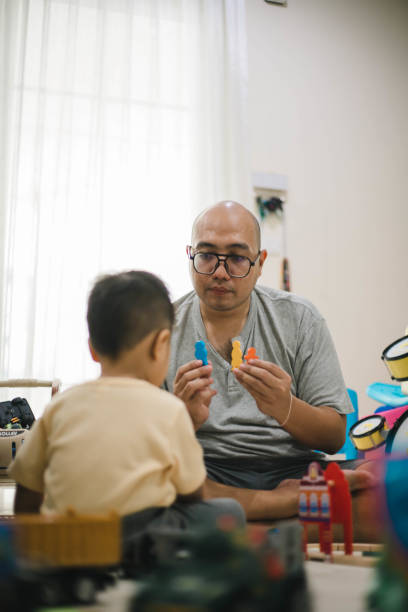 istock asian father and small son playing at home 1471873873