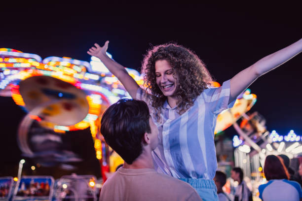 istock Young Couple Embracing Each Other  In Amusement Park 1471875518