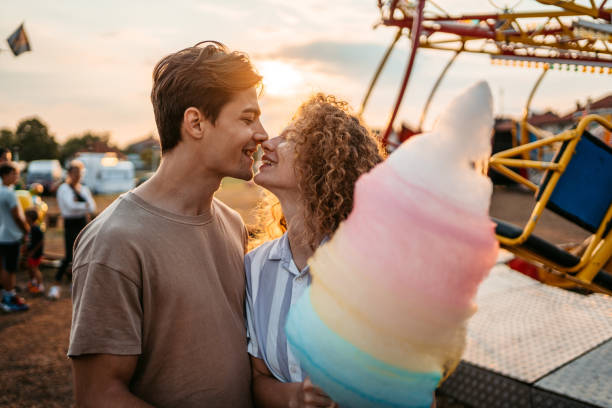 istock Young Couple With Cotton Candy In Amusement Park 1471876332