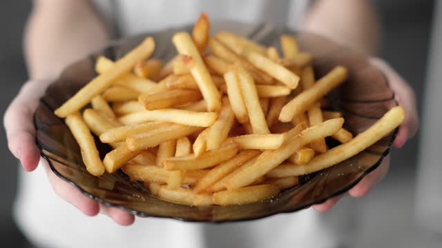 French fries on a plate. Vegetarian food. Cyclic movement, The concept of malnutrition.