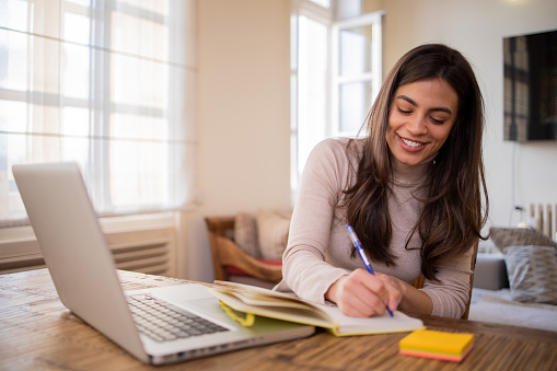 Happy young woman is enjoying working from home