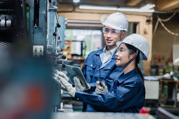 Technical staff working while checking their tablet devices Technical staff working while checking their tablet devices digital transformation factory stock pictures, royalty-free photos & images