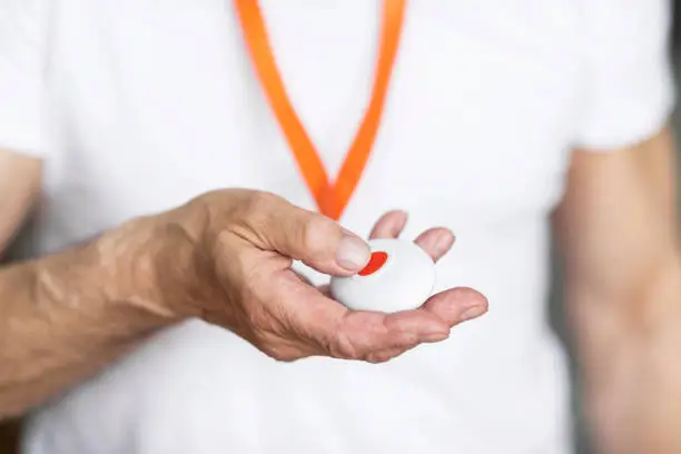 Photo of Unrecognizable senior man pushing panic button on emergency equipment