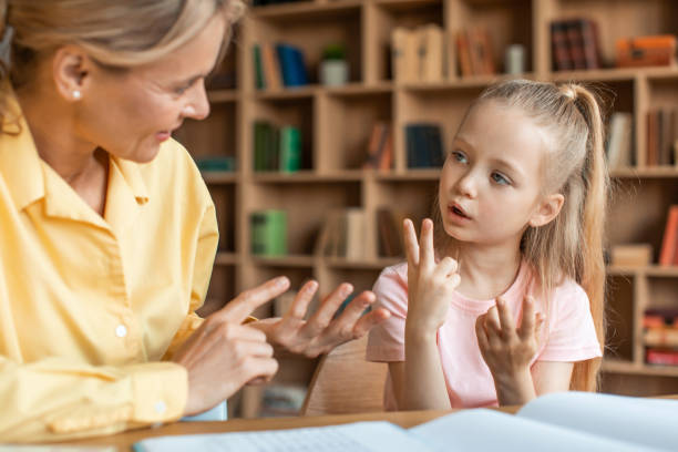 家庭教師のオフィスで指を頼りにしているかわいい女の子、数字と数え方を学ぶ子供 - language therapy ストックフォトと画像