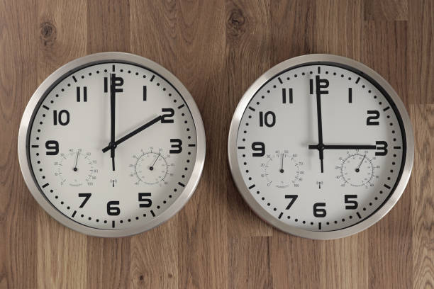 istock Two clocks, one showing two o'clock, the other showing three o'clock.  Time change symbol. 1471885205