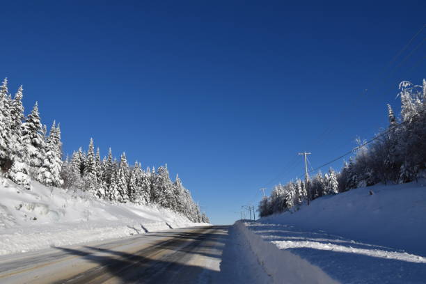 Un ciel bleu Une route de campagne en hiver, Saint-Paul, Québec, Canada ciel bleu stock pictures, royalty-free photos & images