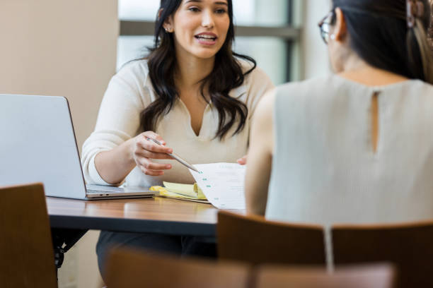 istock Businesswoman asks unrecognizable co-worker about item on report 1471886583
