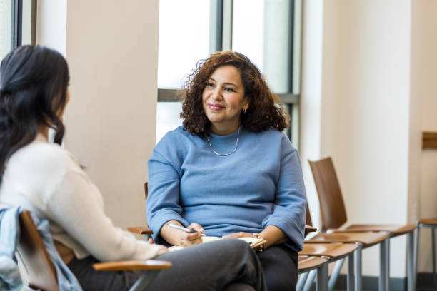 Female human resources rep smiles encouragingly at female employee - fotografia de stock