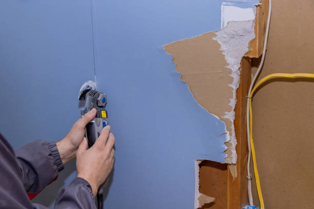 istock Renovation service work in the house cutting off damaged plasterboard with using a oscillating multi tool 1471886926