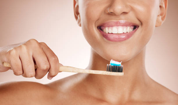 donna, cosmetici e lavarsi i denti per l'igiene dentale, sorriso e bocca pulita sullo sfondo dello studio. spazzolino femmina, ragazza e denti per la salute orale, l'assistenza sanitaria e l'alito fresco per la cura naturale o il relax - lifestyles toothy smile care beauty foto e immagini stock