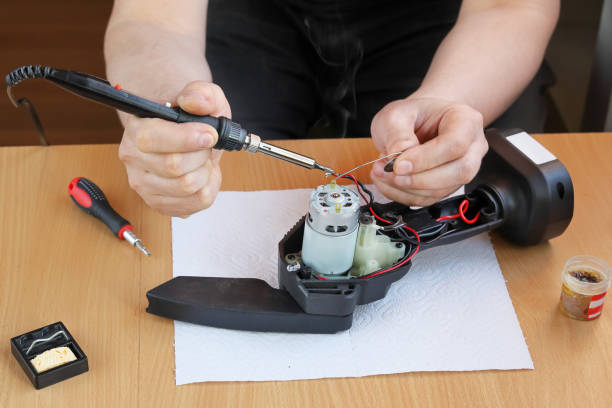 istock Hands soldering wire to electric motor when repairing tool 1471887750