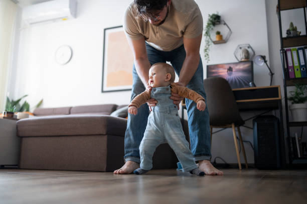 istock Little baby boy learning how to walk with daddy. 1471888729