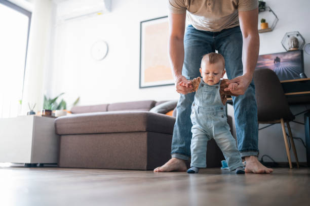istock Little baby boy learning how to walk with daddy. 1471888736