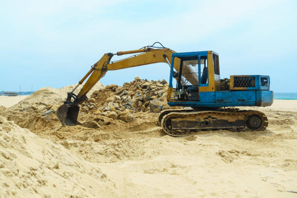istock Excavator with a bucket stands on the sand on the beach 1471890919