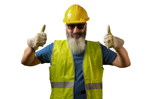 Man with white beard dressed in yellow helmet and reflective vest holding thumbs up