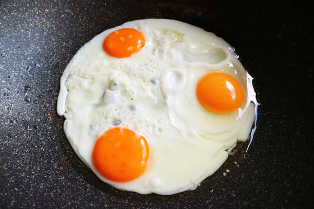 istock Closeup three of hen eggs being fried in a pan 1471893540