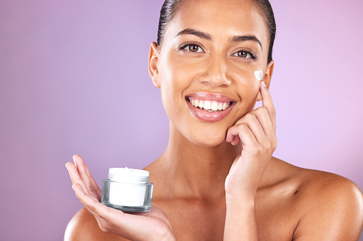 istock Woman, skincare cream and portrait with smile, cosmetic beauty and healthy facial by lavender background. Model, face and cosmetics for natural glow, happiness and product by purple studio background 1471894176
