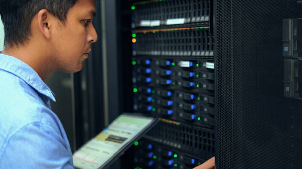 System administrator working with tablet in data center. System administrator working with tablet in data center. mainframe stock pictures, royalty-free photos & images