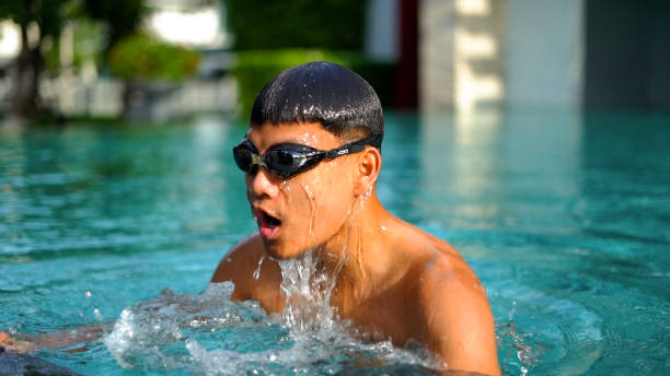 young man swimming in hotel swimming pool. stock photo