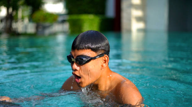 young man swimming in hotel swimming pool. stock photo