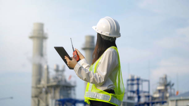 Industrial engineer using digital tablet for work against the background of electrical power plant. stock photo