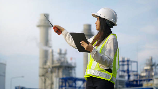 Industrial engineer using digital tablet for work against the background of electrical power plant. stock photo