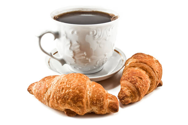 istock Hot coffee cup and delicious croissants on white 1471895229