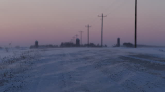 Snow drift across a frozen country rode at dusk
