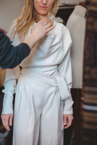 istock Fitting in the tailor's salon, adjusting details on newly made clothes 1471896051
