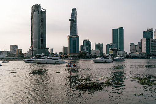 HOCHIMINH CITY, VIETNAM - JANUARY 22, 2022: Sunset on the Saigon River in Thu Duc City, looking over District 1, you can see Bitexco Tower and IFC One. Have a luxury yacht on the river