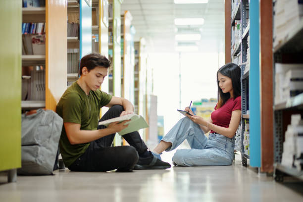 high school students in library - sophomore стоковые фото и изображения