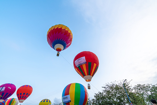 HOCHIMINH CITY, VIETNAM - JANUARY 23, 2022: A hot-air balloon festival kicked off to celebrate the first founding anniversary of Thu Duc City, colorful hot air balloons. Hot air balloon in flight over blue sky