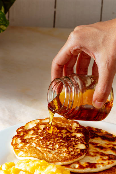 istock Hand pouring honey into homemade pancakes 1471901935
