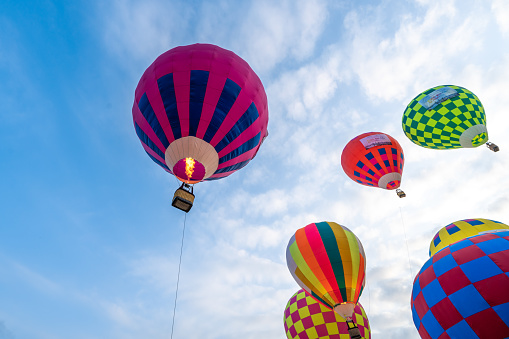 HOCHIMINH CITY, VIETNAM - JANUARY 23, 2022: A hot-air balloon festival kicked off to celebrate the first founding anniversary of Thu Duc City, colorful hot air balloons. Hot air balloon in flight over blue sky