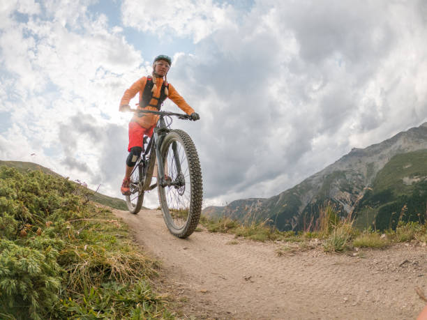istock Young woman mountain biker rides along trail in Summer 1471904143