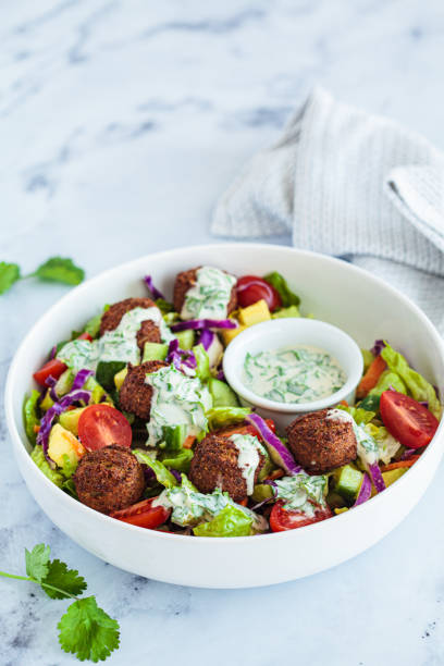 istock Falafel salad with avocado, tomato and tahini dressing. 1471905110