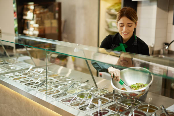 istock Attractive woman working at a salad bar 1471906361
