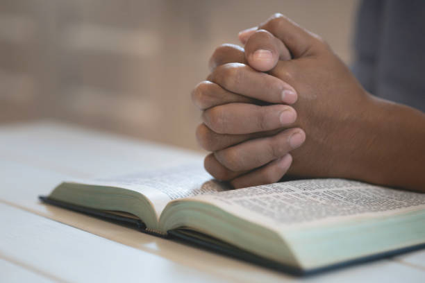 istock Man's Praying Hands Over The Bible. 1471906497