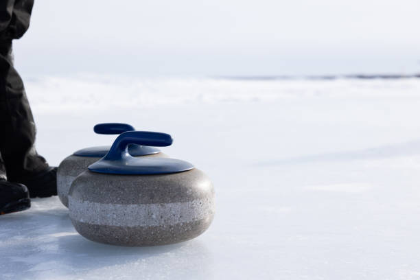 istock Curling rocks by feet on outdoor rink 1471908139