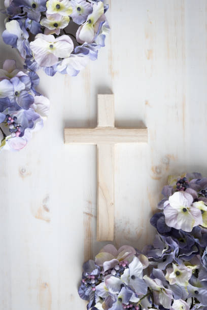 istock Cross and purple flowers on white 1471908200