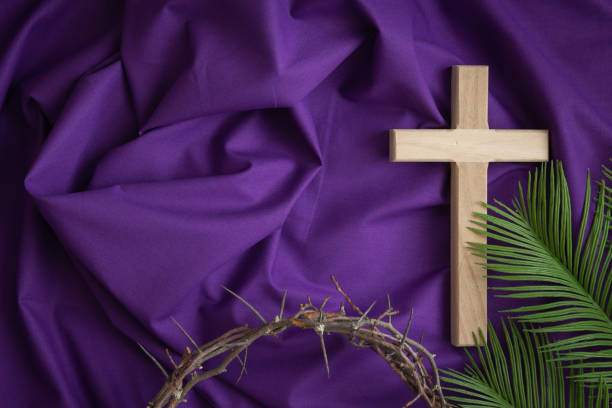 istock Cross, crown of thorns and palm leaf border on purple 1471908391