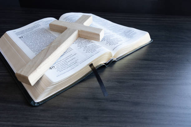 istock Wood cross laying on open bible 1471908467