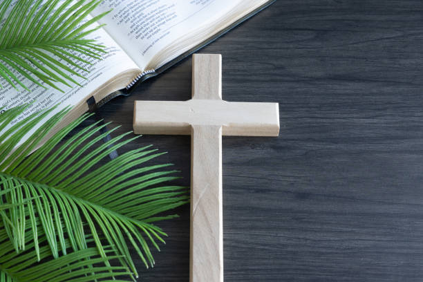 istock Open bible, cross and palm leaves on a dark wood table 1471908495