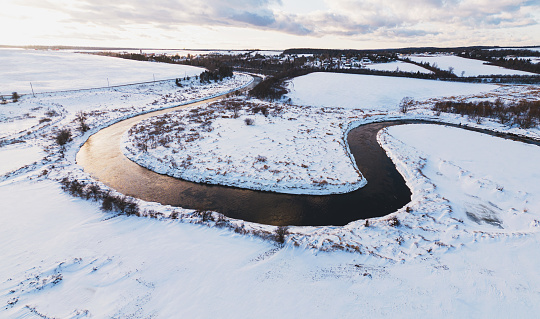 Aerial drone view of a river winding through a Winter landscape.