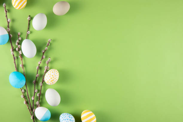 Flowers and Coloured Easter Eggs on Light Green Background stock photo